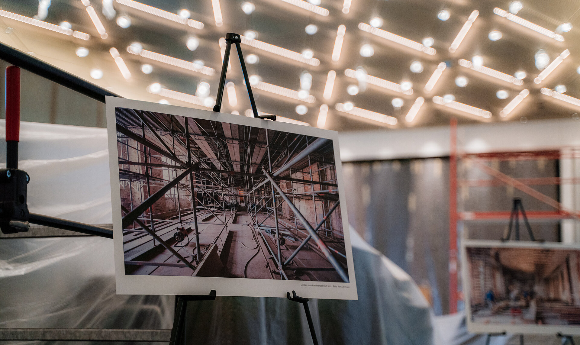 Fotoausstellung in einem modern beleuchteten Raum auf der Baustelle im Konferenzbereich des Burgseeflügels des Schweriner Schlosses mit eingerüstetem Innenraum und Bauarbeiten.