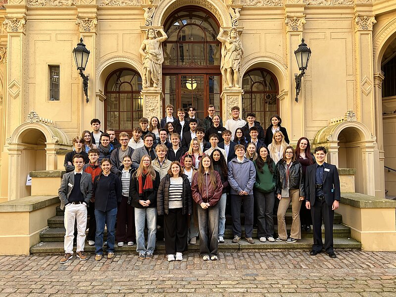 Eine Gruppe Jugendlicher steht auf der Treppe vor einem historischen Gebäude im Schweriner Schloss