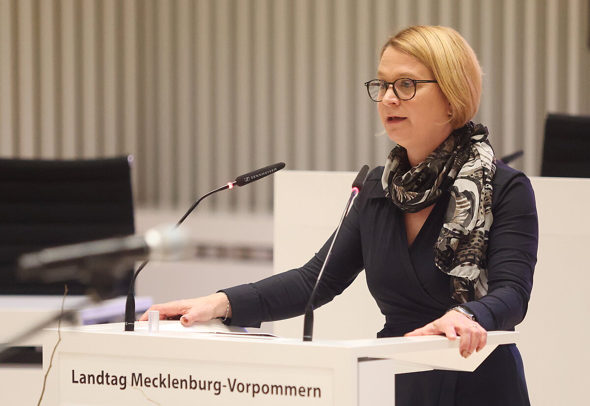 Landtagspräsidentin Birgit Hesse steht am Rednerpult im Plenarsaal des Schweriner Schlosses und hält ein Grußwort