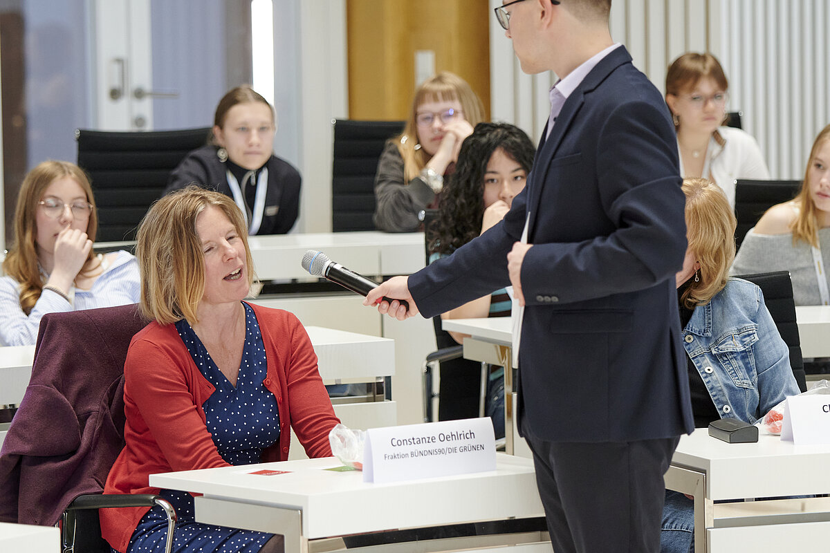 Abgeordnete Constanze Oehlrich (Fraktion BÜNDNIS90/DIE GRÜNEN) im Austausch mit jungen Debattierenden im Plenarsaal des Landtages Mecklenburg-Vorpommern