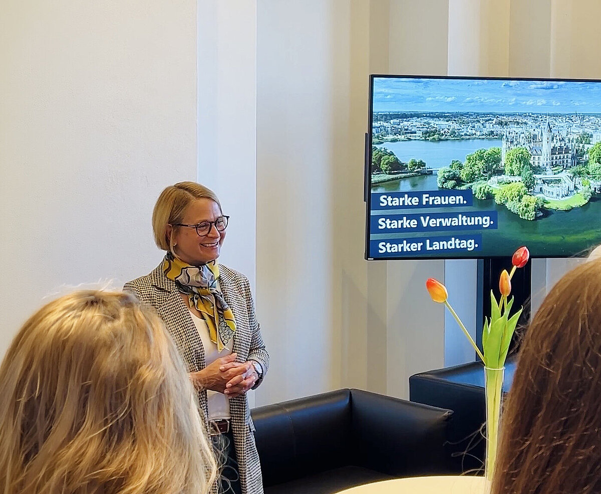 Landtagspräsidentin Birgit Hesse beim Get-together zum Internationalen Frauentag vor Bildschirm mit Aufschrift „Starke Frauen. Starke Verwaltung. Starker Landtag.“