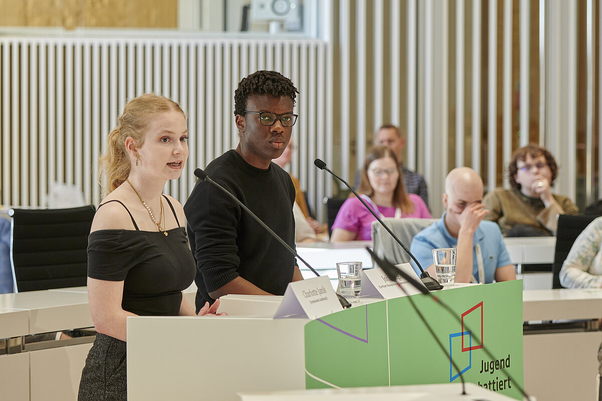 Teilnehmerin und Teilnehmer von ‚Jugend debattiert‘ am Rednerpult im Plenarsaal des Landtages Mecklenburg-Vorpommern