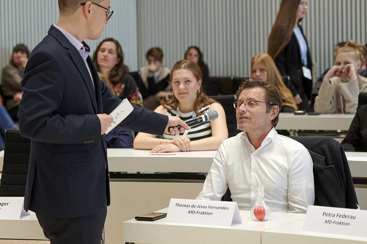 Abgeordneter Thomas de Jesus Fernandes (AfD-Fraktion) im Austausch mit jungen Debattierenden im Plenarsaal des Landtages Mecklenburg-Vorpommern