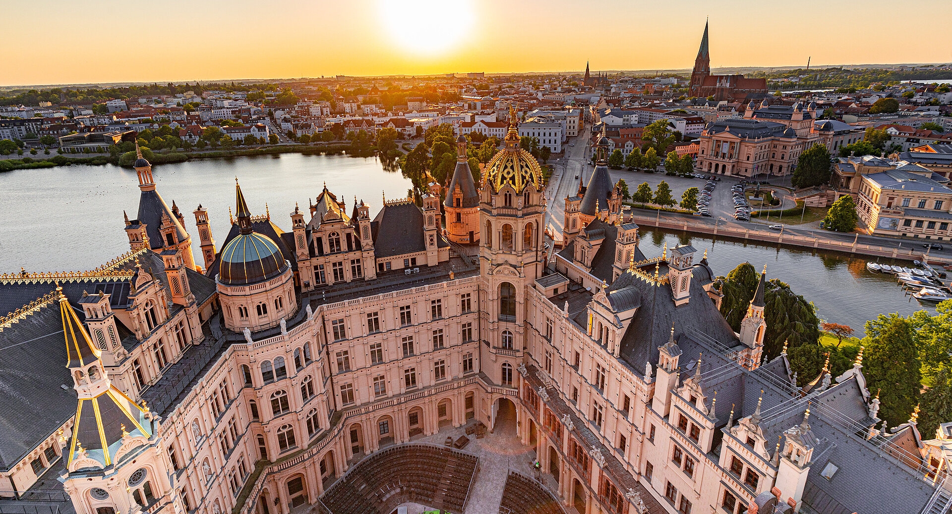 Luftaufnahme des Schweriner Schlosses bei Sonnenuntergang mit Blick über die Altstadt und den Schweriner See.