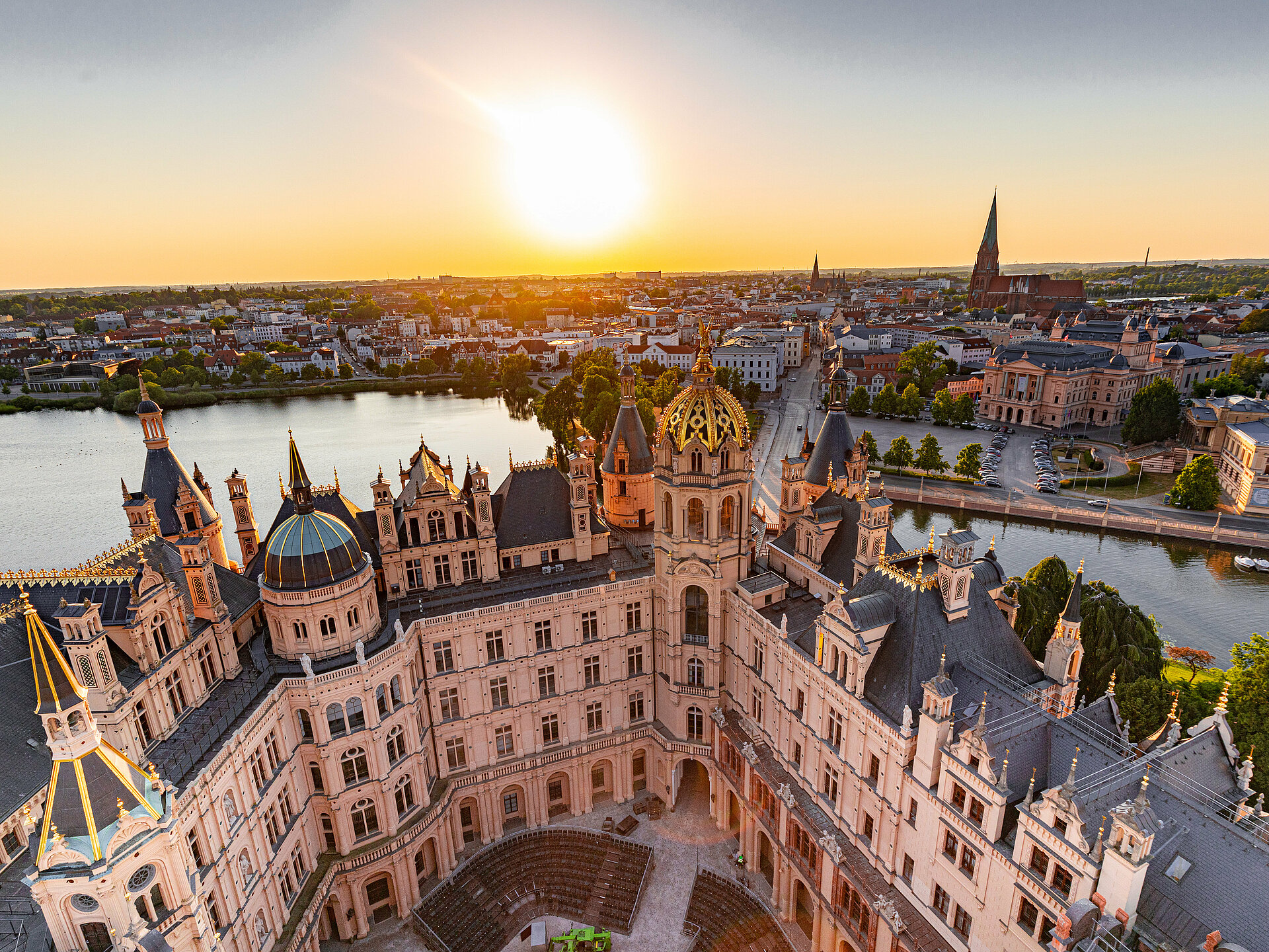 Luftaufnahme des Schweriner Schlosses bei Sonnenuntergang mit Blick über die Altstadt und den Schweriner See.