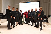 Gruppenfoto mehrerer Personen im Plenarsaal des Schweriner Schlosses vor dem Rednerpult