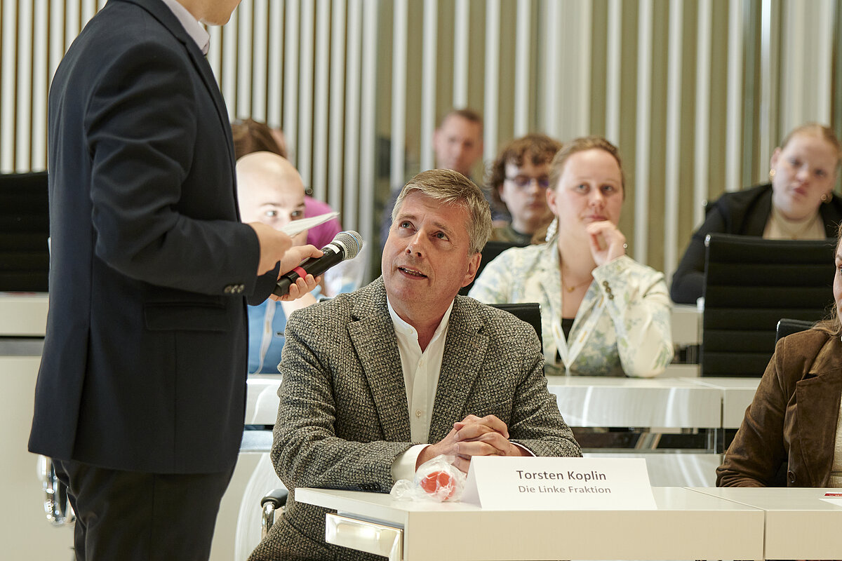 Abgeordneter Torsten Koplin (Die Linke Fraktion) im Austausch mit jungen Debattierenden im Plenarsaal des Landtages Mecklenburg-Vorpommern