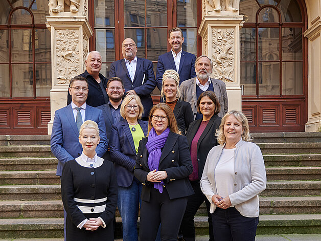 Mitglieder des Sozialausschusses stehen als Gruppe im Innenhof des Schweriner Schlosses vor der Hofdornitz