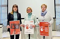 Die Präsidentin und die Vizepräsidentinnen des Landtages halten Schilder hoch mit der Aufschrift "Stopp Gewalt gegen Frauen"
