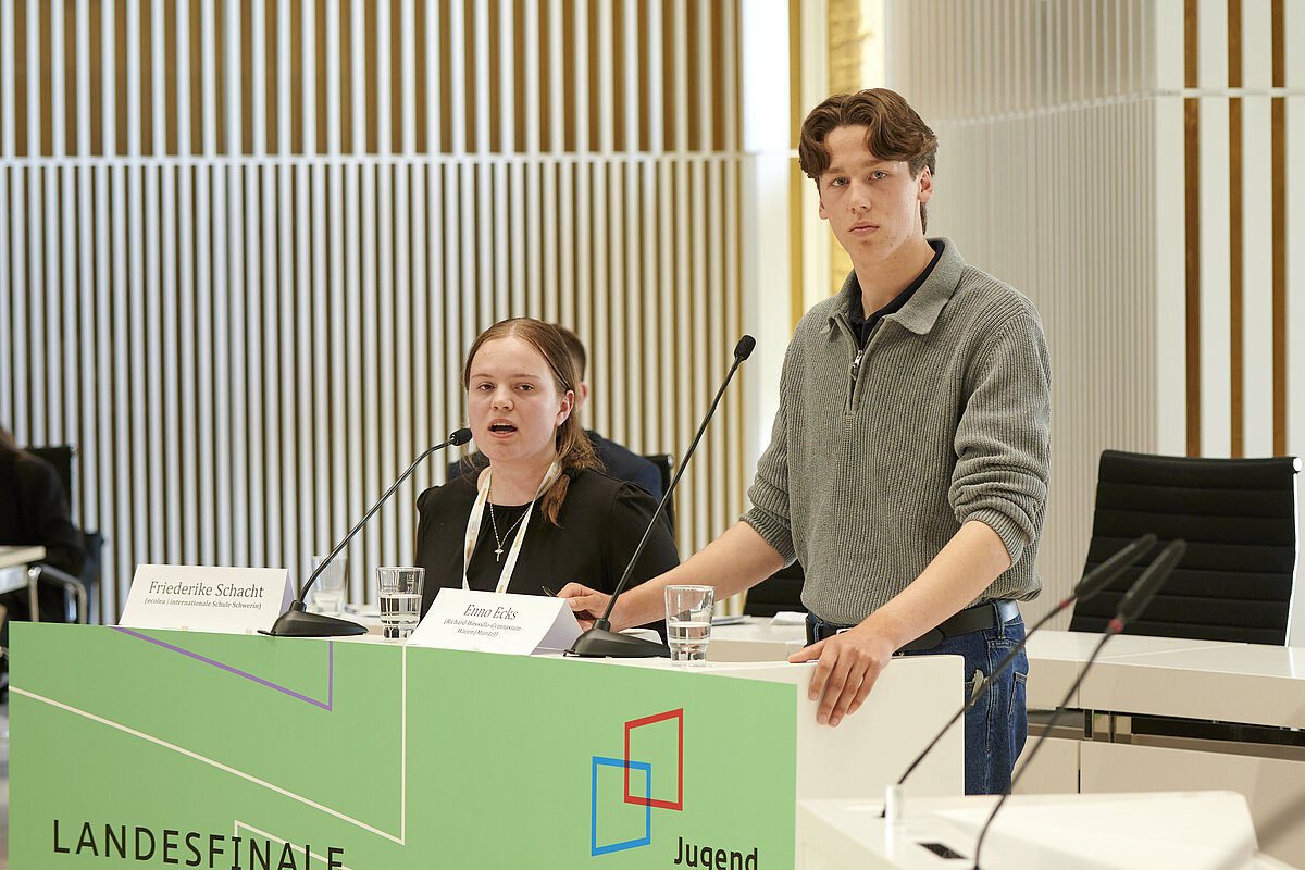 Teilnehmerin und Teilnehmer von ‚Jugend debattiert‘ am Rednerpult im Plenarsaal des Landtages Mecklenburg-Vorpommern
