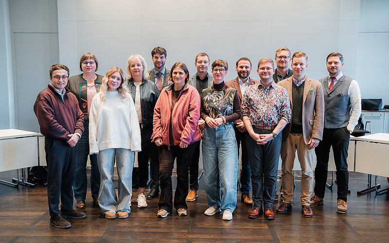 Eine Gruppe Abgeordneter und Jugendlicher im Konferenzsaal