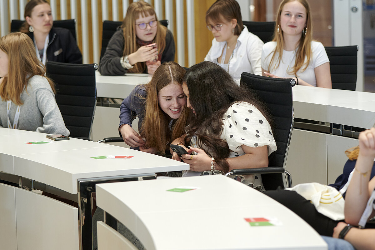 Im Plenarsaal des Landtages Mecklenburg-Vorpommern beraten sich Teilnehmerinnen von ‚Jugend debattiert‘ an ihren Plätzen.