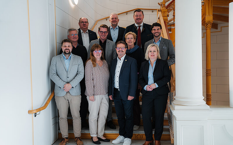 Eine Gruppe Abgeordneter steht auf einer Treppe im Schweriner Schloss